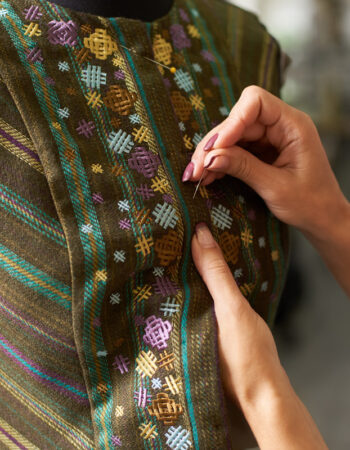 female-designer-hands-with-pins-fitting-jacket-on-2026-03-17-01-40-18-utc